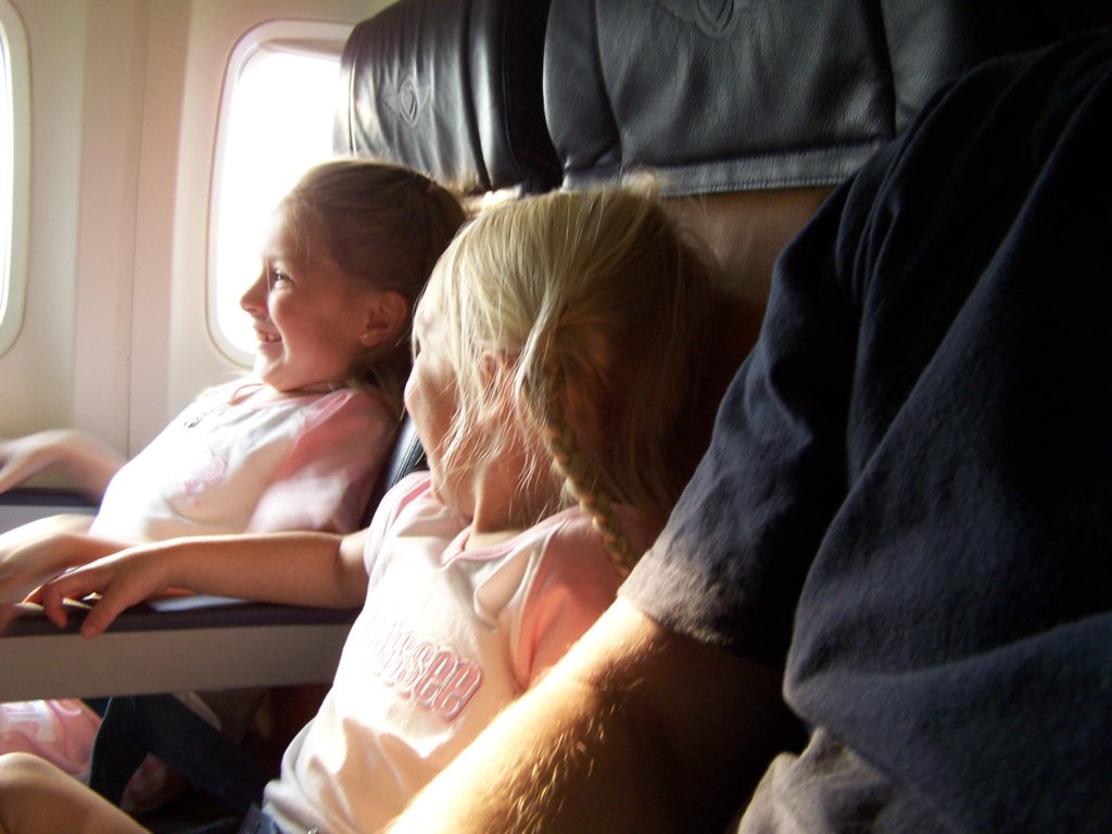 a couple of children sitting on an airplane