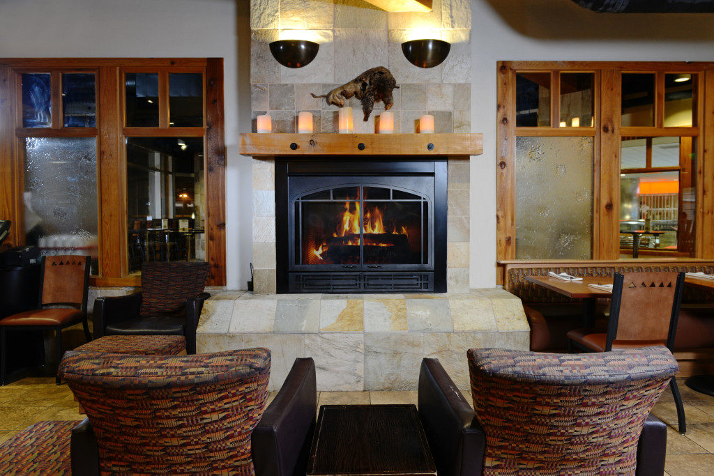 a fireplace in a room with chairs and a table