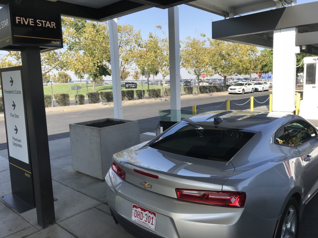 a silver car parked at a gas station